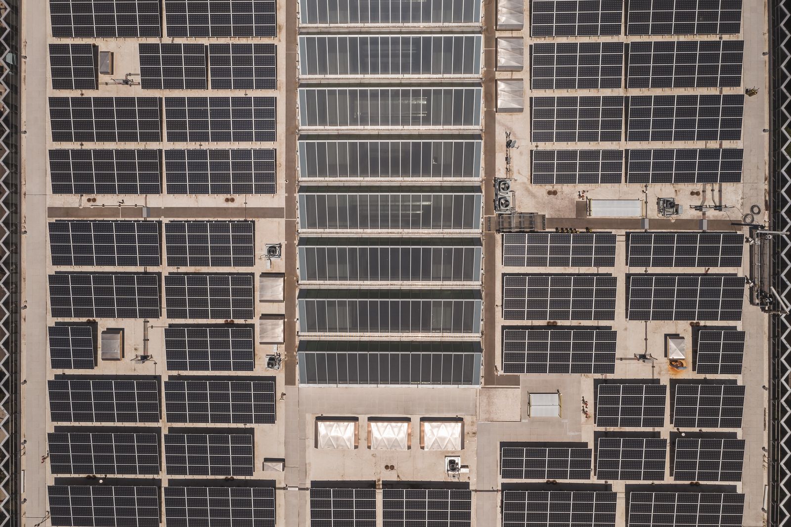 Aerial view of a large commercial solar panel array on an industrial rooftop