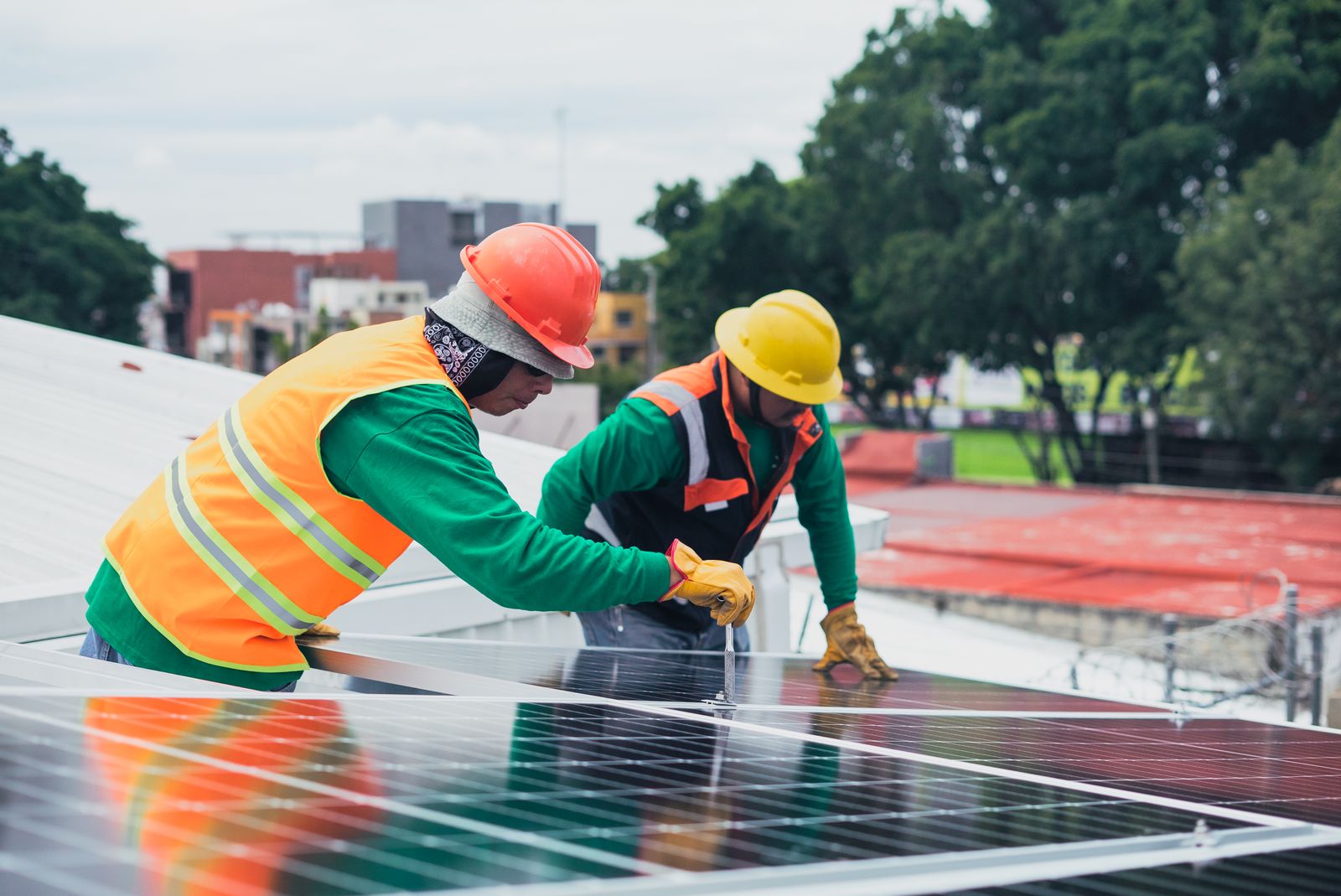 Technicians installing rooftop solar panels on a residential home